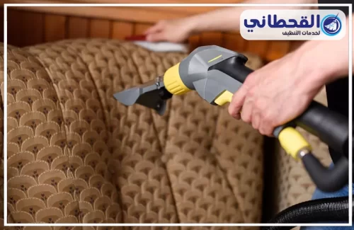 تنظيف كنب المجالس بالرياض | 0548145142 | شركة القحطاني فني يستخدم المكنسة الكهربائية على الأريكة، يعرض خدمات التنظيف الاحترافية في الرياض.