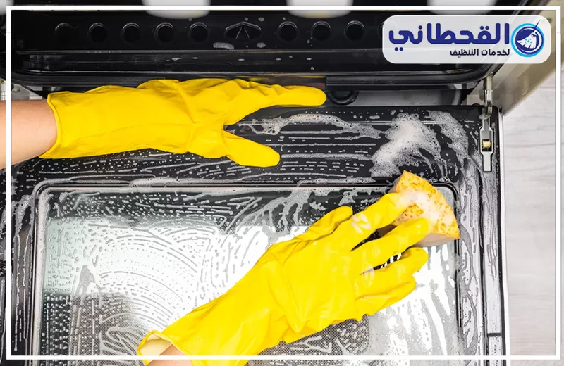 غسيل أفران بالقطيف 0548145142 القحطاني فني يستخدم اسفنجة لغسيل أفران بالقطيف، ممسحاً بقوة سطح زجاجي مغطى بالصابون لإزالة الشحوم.