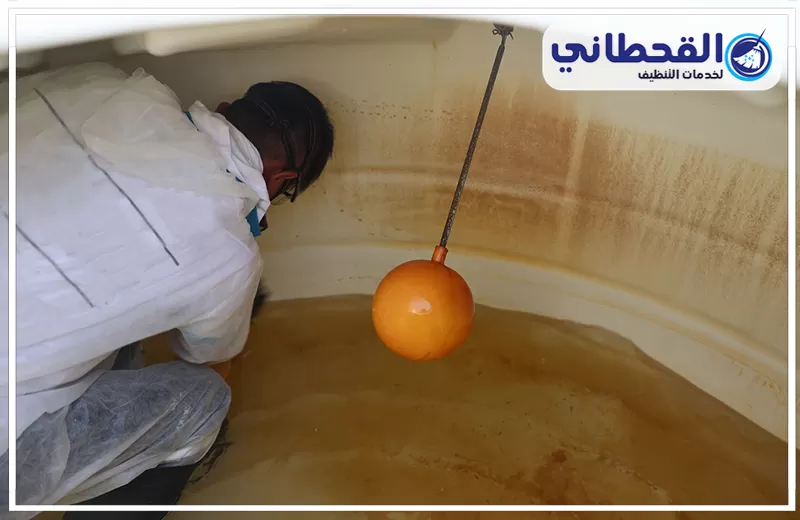 تواصل معنا على تنظيف الخزان الارضي بصفوى 0548145142 شركة القحطاني. فني داخل خزان مياه يفحص الرواسب والاتساخات المتراكمة على القاع والجدران بجوار عوامة الخزان قبل بدء التنظيف.