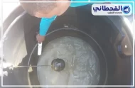 فني يستخدم أداة لتنظيف خزان كبير في شركة تنظيف خزانات بالخبر.