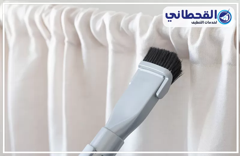 تنظيف ستائر داخل المنزل برأس تنورة 0548145142 شركة القحطاني. فرشاة تنظيف تمر على ستارة بيضاء مع شعار القحطاني لخدمات التنظيف أعلى الصورة