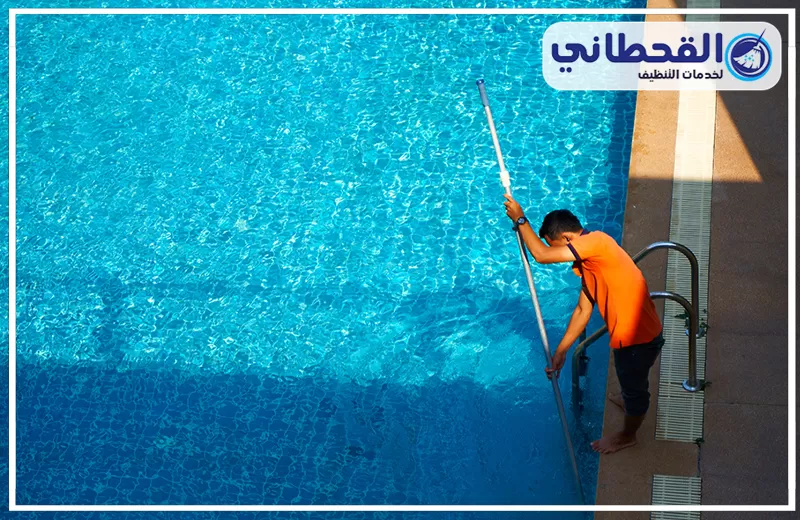 باقات تنظيف مسابح دورية بالخبر 0548145142 شركة القحطاني تنظيف مسبح باستخدام عصا مخصصة لإزالة الشوائب والرواسب من الجوانب، مع ظهور المياه الصافية داخل المسبح.