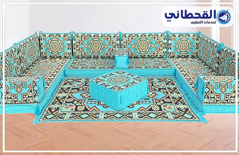 شركة تنظيف مجالس بالبخار بسيهات 0548145142 شركة القحطاني مجلس عربي أرضي بتصميم تراثي وألوان زرقاء مزخرفة، يظهر بترتيب منظم ومساحة جلوس واسعة.