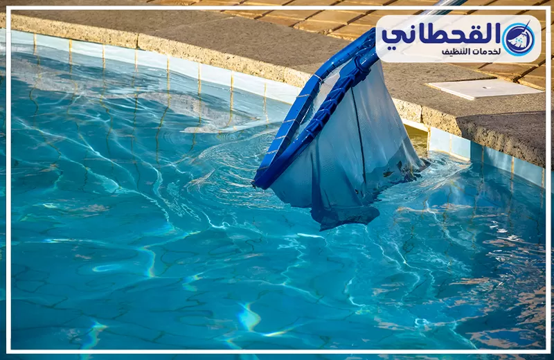 تنظيف وصيانة مسابح بالخبر 0548145142 شركة القحطاني في شركة تنظيف مسابح بالخبر باستخدام شبكة مخصصة لإزالة الشوائب والرواسب من المياه، مع ظهور حواف المسبح والمياه الصافية.