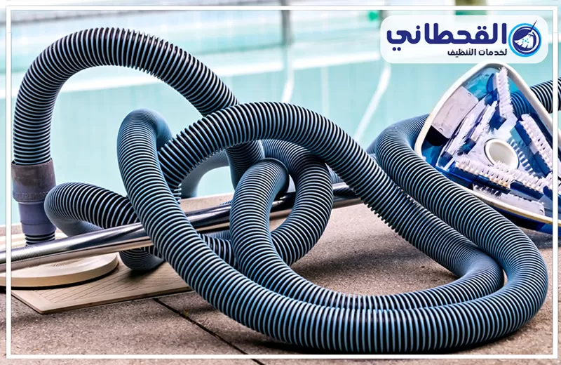 كشف تسربات المسابح بسيهات 0548145142 شركة القحطاني خراطيم ومعدات تنظيف مسابح موضوعة بجانب المسبح، وتُستخدم في سحب الشوائب وتنظيف المياه والجدران.